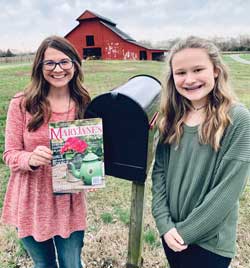 Holly and daughter with magazine at mailbox